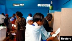 Une femme se rend dans un isoloir pour voter dans un bureau de vote à Gatundu, Kenya, le 4 mars 2013. 