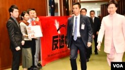 香港特首林鄭月娥步入立法會會議廳時遇到民主派議員抗議。