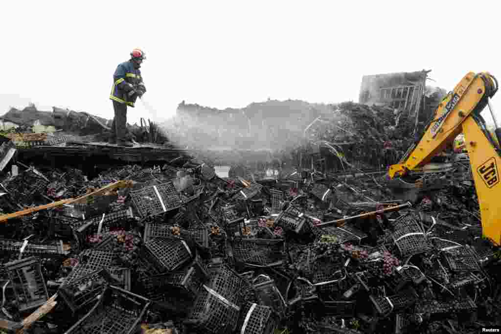 A firefighter sprays water on crates of grapes after a massive car accident on a motorway in northern Greece. Greek media reported that a truck caused a pile-up with dozens of cars in which four people were killed and at least 20 were injured on Egnatia motorway a few kilometers off Thessaloniki.