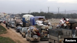 FILE - A general view of vehicles carrying belongings of internally displaced Syrians from western Aleppo countryside, in Hazano near Idlib, Syria, Feb. 11, 2020.