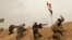FILE - Fighters from Badr Brigades Shiite militia clash with Islamic State group militants at the front line on the outskirts of Fallujah, Anbar province, Iraq, June 1, 2015. 
