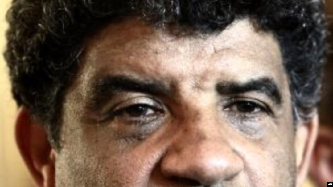 Abdullah al-Senoussi, head of Libyan intelligence, speaks to the press as gunfire erupts all around the Rixos hotel in Tripoli, Libya. (File Photo - August 21, 2011)