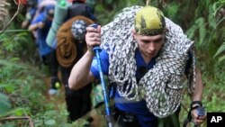 Rescuers from Russian ministry of emergency situation walk on the way to the crash site of the Sukhoi Superjet-100 at Mount Salak in Bogor, West Java, Indonesia, May 13, 2012. 