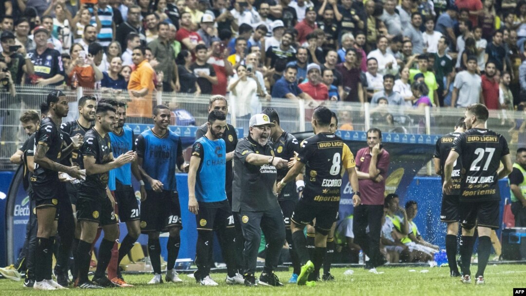 Diego Maradona (tengah) merayakan kemenangan bersama tim asuhannya dalam pertandingan pertamanya sebagai pelatih klub divisi dua, Dorados. Dorados menang 4-1 melawan Cafetaleros di Stadion Banorte di Culiacan, negara bagian Sinaloa, Meksiko, 17 September 2018.