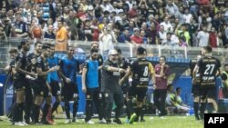 Diego Maradona (tengah) merayakan kemenangan bersama tim asuhannya dalam pertandingan pertamanya sebagai pelatih klub divisi dua, Dorados. Dorados menang 4-1 melawan Cafetaleros di Stadion Banorte di Culiacan, negara bagian Sinaloa, Meksiko, 17 September 2018.