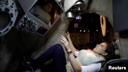 Seorang perempuan sedang mengenakan purwarupa rompi pelindung buatan Stemrad, Astrorad, duduk di dalam pesawat luar angkasa milik Rusia, Excalibur-Almaz Space Capsule dalam sebuah demonstrasi untuk Reuters di Madatech Space, di Haifa, Israel, 23 Februari 2017.