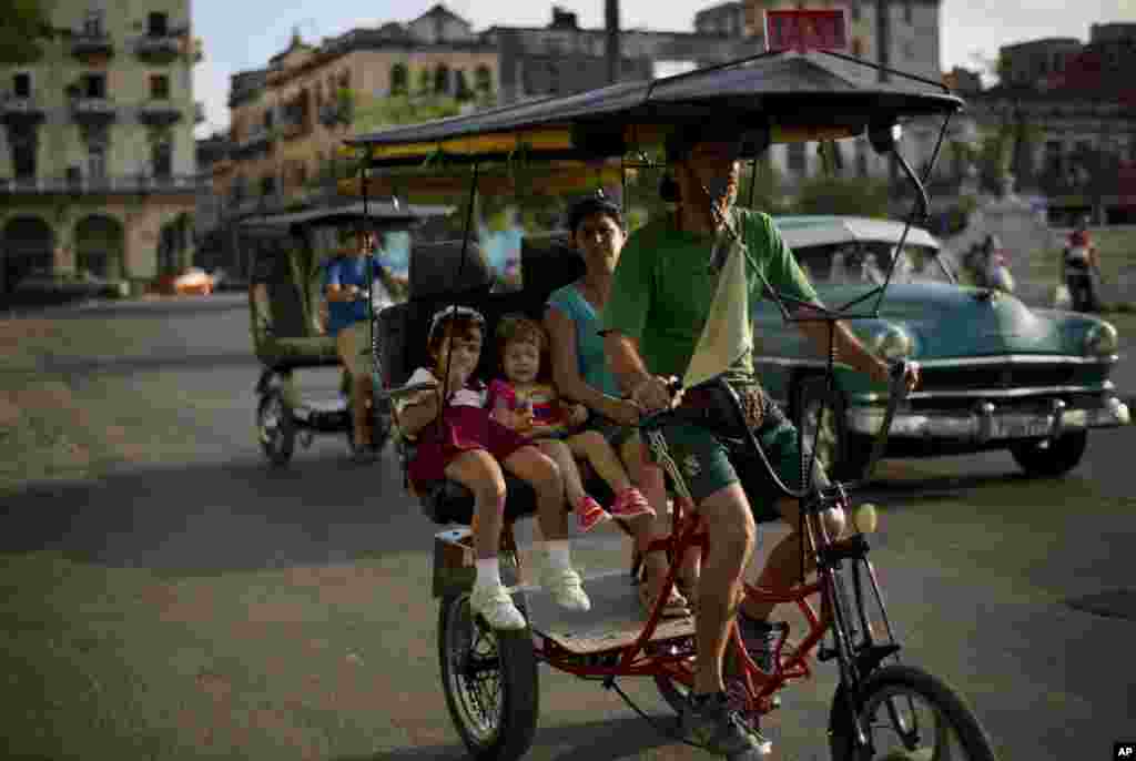 A woman with two girls travel in a rickshaw through the center of Havana, Cuba, Jan. 19, 2015. Cuba has so far offered a guardedly positive reception to President Barack Obama&#39;s loosening of the trade embargo on Cuba, saying it welcomes the full package of new economic ties on offer, but it insists it will maintain its one-party political system and centrally planned economy.