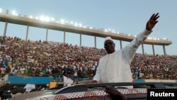 Le président sénégalais et candidat aux prochaines élections présidentielles, Macky Sall, souhaite la bienvenue à ses partisans alors qu'il arrive à sa dernière manifestation à Dakar, le 22 février 2019.