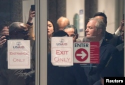 Sen. Chris Van Hollen (D-MD) stands behind the door of the U.S. Agency for International Development (USAID) offices, in Washington, Feb. 3, 2025.