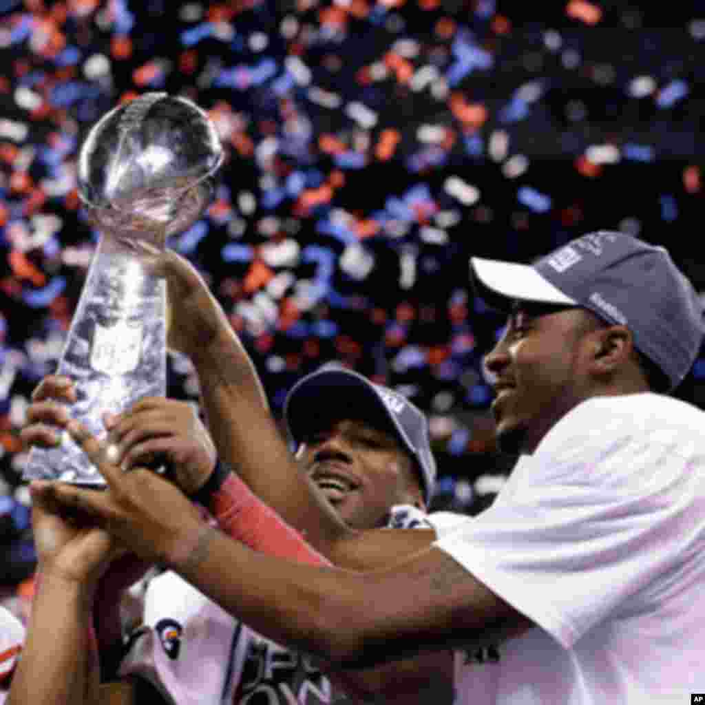 New York Giants players including wide receiver Victor Cruz, left, and wide receiver Hakeem Nicks, right, celebrate their team's 21-17 win over the New England Patriots in the NFL Super Bowl XLVI football game, Sunday, Feb. 5, 2012, in Indianapolis.