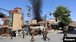 Asap hitam mengepul dari arah terdengarnya suara tembakan dan ledakan di kota Jalalabad, Afghanistan, 31 Juli 2018.