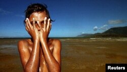 Seorang anak Aborigin bermain di dekat Cape Tribulation, Queensland. Setelah pergulatan hukum selama 30 tahun, kelompok-kelompok pribumi Semenanjung Cape York, Australia, merayakan dikembalikannya tanah kesukuan seluas lebih dari 160 ribu hektar.