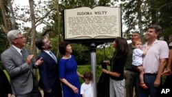 Jon Parrish Peede, chairman of the National Endowment for the Humanities, second from left, joins Gov. Phil Bryant, left, and members of celebrated writer Eudora Welty's family in unveiling the inaugural Mississippi Writers Trail marker, outside Welty's house in Jackson, Miss., Sept. 10, 2018.