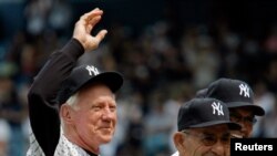 FILE - Whitey Ford waves beside Yogi Berra and Reggie Jackson during a New York Yankees Old Timers Day game introduction at Yankee Stadium in New York, July 7, 2007. 