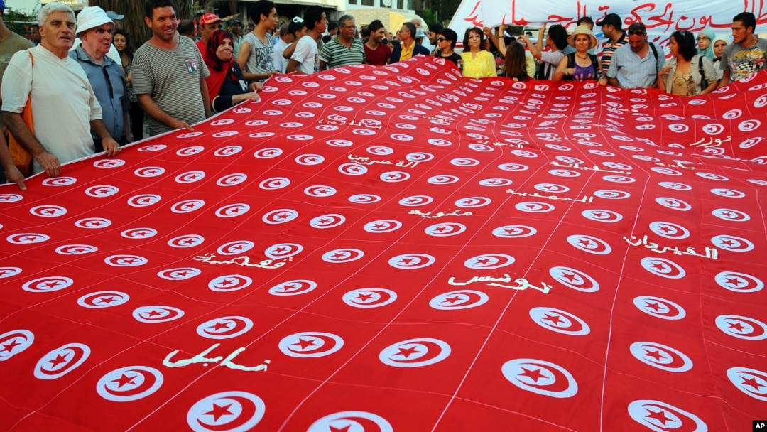 Bendera Tunisia dibentangkan dalam demonstrasi melawan pemerintahan Islamis di Tunis, September 2013. (Foto: Dok)