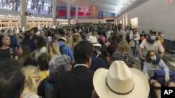 In this photo provided by Austin Boschen, people wait in line to go through the customs at Dallas Fort Worth International Airport in Grapevine, Texas, Saturday, March 14, 2020. International travelers reported long lines at the customs at the airport Sat