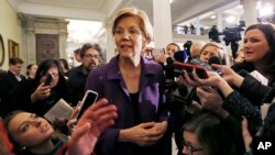 Democratic Sen. Elizabeth Warren is surrounded by reporters at the Massachusetts Statehouse, Jan. 2, 2019, in Boston.