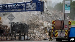 Crews work in the rubble of the Champlain Towers South condo building, as removal and recovery work continues at the site, in Surfside, Florida, July 12, 2021.