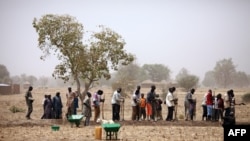 Des gens travaillent le 21 mars 2012 dans un champ dans le cadre d'un programme de travail contre rémunération géré par une ONGpour construire des digues pour retenir l'eau près de Diapaga au nord-est de Ouagadougou. (Photo de RAPHAEL DE BENGY / AFP)