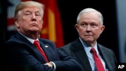 FILE - President Donald Trump sits with Attorney General Jeff Sessions during the FBI National Academy graduation ceremony in Quantico, Va.