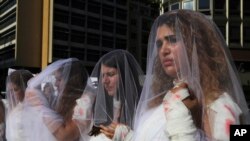 Para perempuan Lebanon mengenakan baju pengantin yang dibubuhi pewarna merah darah dalam unjuk rasa memprotes peraturan yang membebaskan pemerkosa jika menikahi korbannya, di Beirut, Lebanon, 6 Desember 16. 