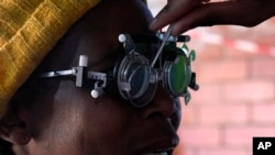 FILE - A patient eyes are tested for lenses to be made for a new pair of glasses outside the Phelophepa eye clinic carriage, in Tembisa east of Johannesburg, South Africa, Aug. 22, 2024.