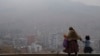 Una mujer acompaña a su hija a la escuela en medio del humo de los incendios forestales en La Paz, Bolivia, el lunes 9 de septiembre de 2024. 