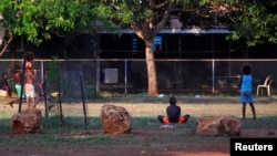 Members of the Australian Aboriginal community of Ramingining can be seen near their homes in East Arnhem Land, located east of the Northern Territory city of Darwin, Australia, Nov. 24, 2014.