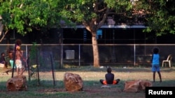 FILE - Members of the Australian Aboriginal community of Ramingining can be seen near their homes in East Arnhem Land, located east of the Northern Territory city of Darwin, Australia, Nov. 24, 2014. (REUTERS/David Gray)