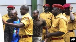 Rwandan citizen Muhamoud Mugisha, right, and his co-accused Ugandan Edris Nsubuga, left, leave the Kampala High Court after their judgment, in Kampala, Uganda, Sept.16, 2011.