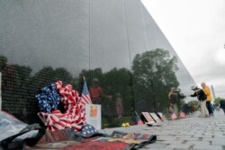 A visitors reads the names of the fallen soldiers at Vietnam Veterans Memorial at the National Mall ahead of Memorial Day, in Washington, Sunday, May 30, 2021. (AP Photo/Jose Luis Magana)