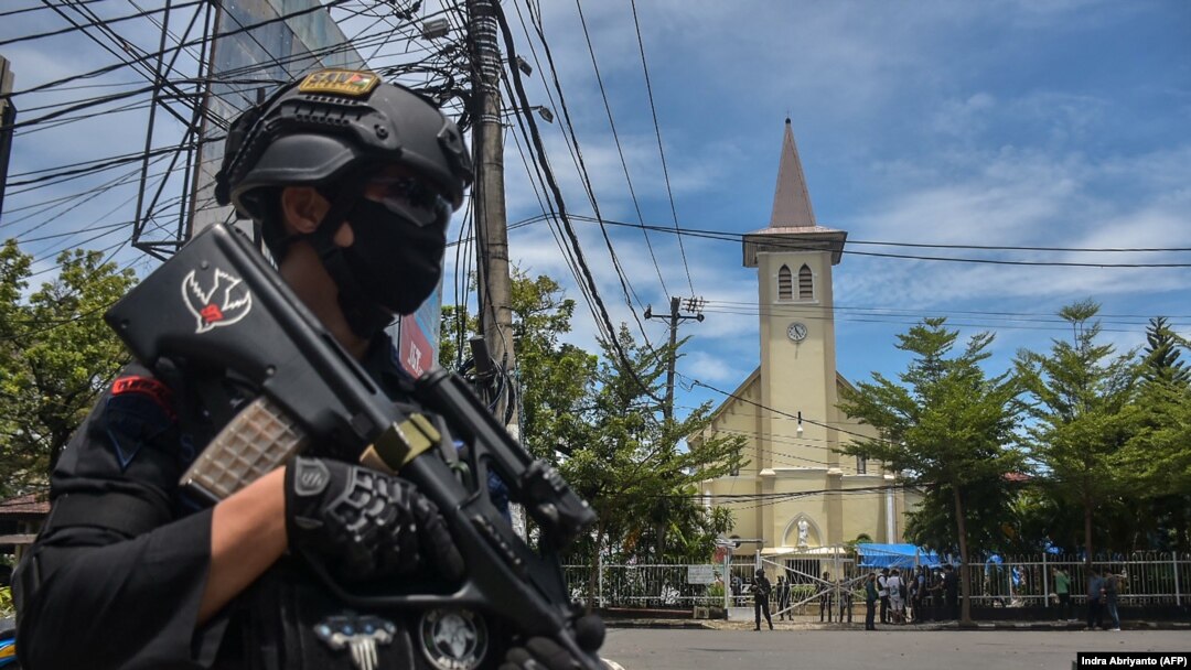 Polisi berjaga di luar gereja pasca ledakan di Makassar pada 28 Maret 2021. (Foto: AFP/Indra Abriyanto)