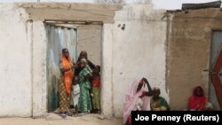 Des femmes regardent passer des militaires à Kerawa, à la frontière du Nigeria où Boko Haram frappe, au Cameroun, le 16 mars 2016.