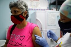 ARCHIVO - Una mujer recibe una dosis de la vacuna china Sinopharm contra el COVID-19 en un centro de salud en Caracas, Venezuela, el 7 de marzo de 2021.