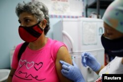 ARCHIVO - Una mujer recibe una dosis de la vacuna china Sinopharm contra el COVID-19 en un centro de salud en Caracas, Venezuela, el 7 de marzo de 2021.