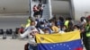 Una familia venezolana posa con la bandera de su país al aterrizar en el aeropuerto internacional Simón Bolívar, de Maiquetía, La Guaira, el 24 de febrero de 2025. AP/Cristian Hernández