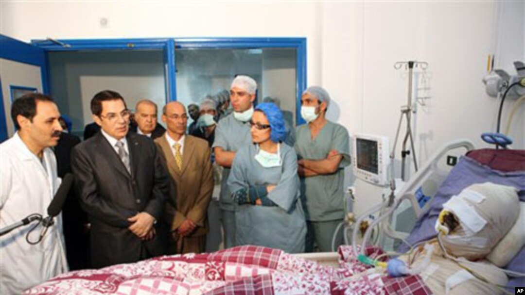 In this photo released 28 Dec 2010 by the Tunisian President's office, Tunisia's President Zine El Abidine Ben Ali, second from left, visits Mohamed Bouazizi, a young man who set himself on fire after police confiscated fruit and vegetables he sold withou