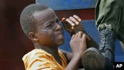 Guinean police detain a young supporter of UFDG presidential candidate Cellou Dalein Diallo suspected of throwing stones and looting in Conakry, 15 Nov., 2010.