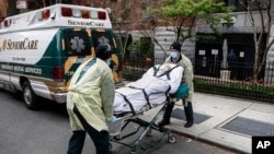 A patient is loaded into the back of an ambulance by emergency medical workers outside Cobble Hill Health Center, Friday, April 17, 2020, in the Brooklyn borough of New York. 
