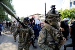 Iraqi Popular Mobilization Forces are seen at a march during the funeral of members of the Shiite group Asaib Ahl al-Haq, who were killed when protesters attacked the group's office during anti-government protests, in Baghdad, Iraq, Oct. 26, 2019.