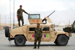 FILE - Afghan soldiers stand guard after the American military left Bagram Airfield, in Parwan province north of Kabul, Afghanistan, July 5, 2021.