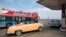 FILE - A vintage car carrying tourists waits in line to fill up with fuel at a gas station as a tourist bus passes by along the seafront boulevard "El Malecon" in Havana, January 12, 2015. 