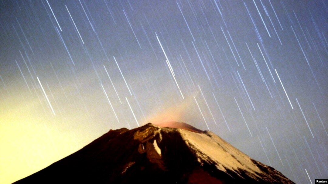 Hujan meteor Geminid menerangi langit di atas gunung berapi Popocatepetl di Meksiko, dekat desa San Nicolas des los Ranchos di negara bagian Puebla, dini hari 14 Desember 2004. Puncak hujan meteor Geminid untuk 2018 diperkirakan pada 13-14 Desember.