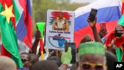 FILE — Supporters of Burkina Faso's latest coup leader Capt. Ibrahim Traore gather outside the National Assembly waving flags and posters of the military leader as he was appointed the nation's transitional president in Ouagadougou, on October 14, 2022.