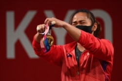 Gold medalist Philippines' Hidilyn Diaz holds her medal on the podium for the victory ceremony of the women's 55kg weightlifting competition during the Tokyo 2020 Olympic Games at the Tokyo International Forum in Tokyo on July 26, 2021.