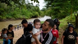 Seorang migran menggendong anaknya setelah berhasil melalui Celah Darien dan tiba di pusat penerimaan migran di desa Lajas Blancas, Panama, pada 26 September 2024. (Foto: Reuters/Enea Lebrun)