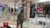 A member of the military walks as he inspects the damage at the looted Jabulani mall as the country deploys army to quell unrest linked to jailing of former President Jacob Zuma, in Soweto, South Africa, July 13, 2021. 