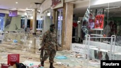 A member of the military walks as he inspects the damage at the looted Jabulani mall as the country deploys army to quell unrest linked to jailing of former President Jacob Zuma, in Soweto, South Africa, July 13, 2021. 