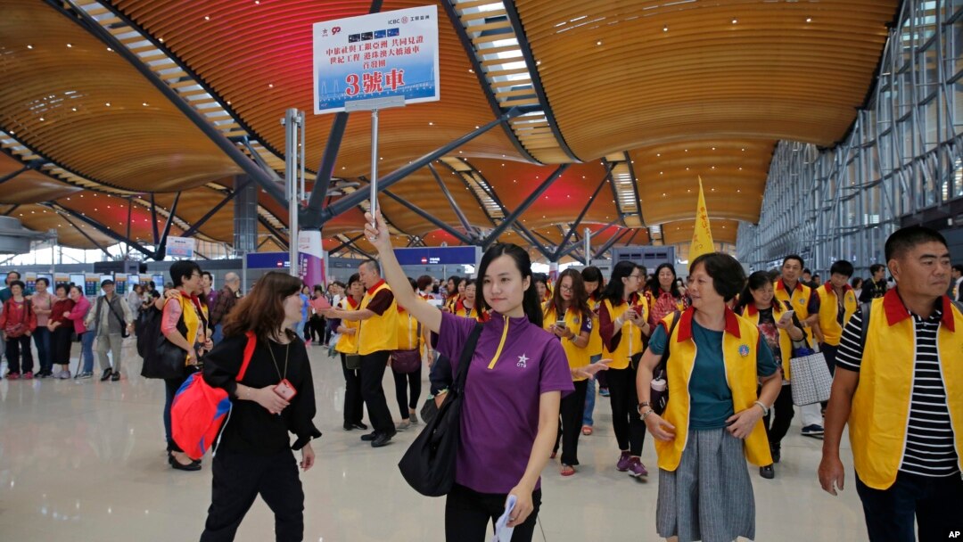 Khách du lịch tại sảnh đi của chiếc cầu mới khánh thành nối Hong Kong với Chu Hải và Macau. Chiếc cầu này được cho là đã góp phần làm tăng lượng khách kỷ lục tới Hong Kong.