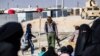 FILE - A member of Kurdish internal security stands guard at the Kurdish-run al-Hol camp, in northeastern Syria, Jan. 28, 2021.